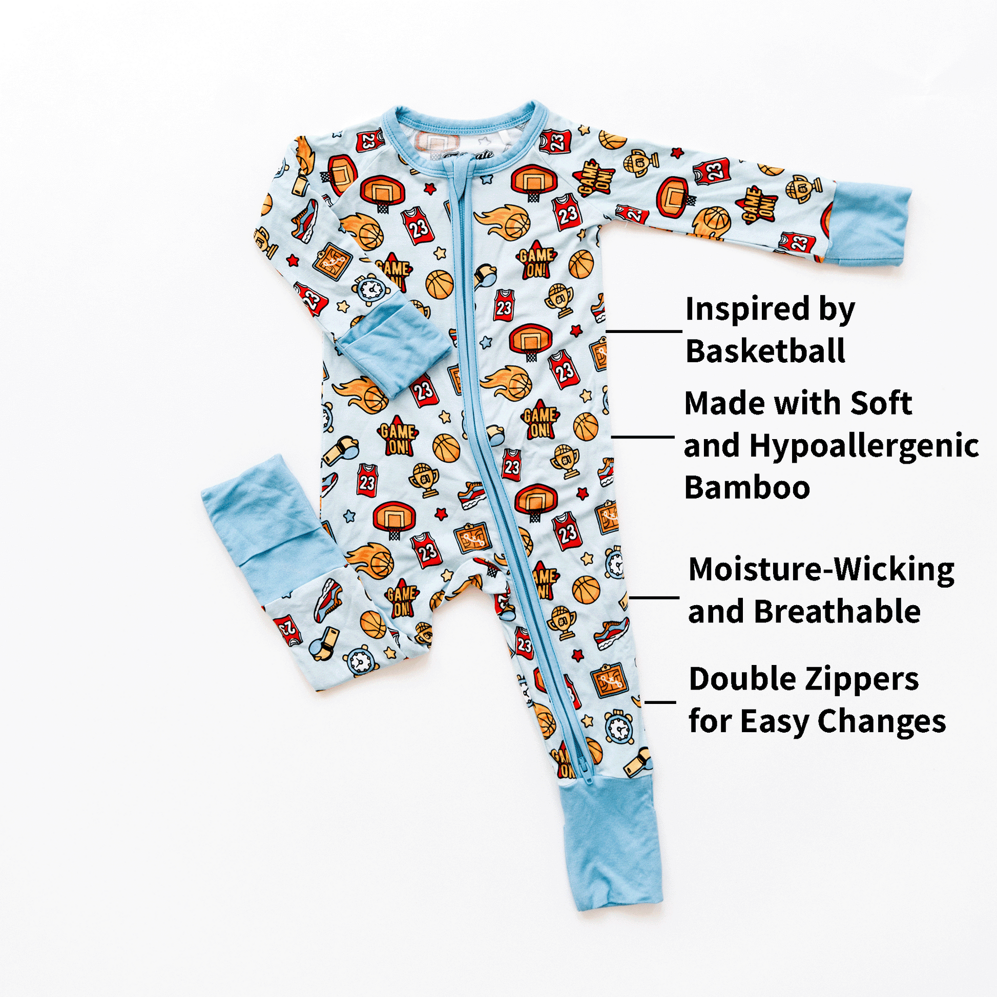 A light blue Basketball Onesie for infants displayed on a white background. The Tailgate Tikes onesie features playful basketball-themed prints, including basketballs, jerseys with the number 23, and other related items. Text highlights on the onesie describe its features and materials.