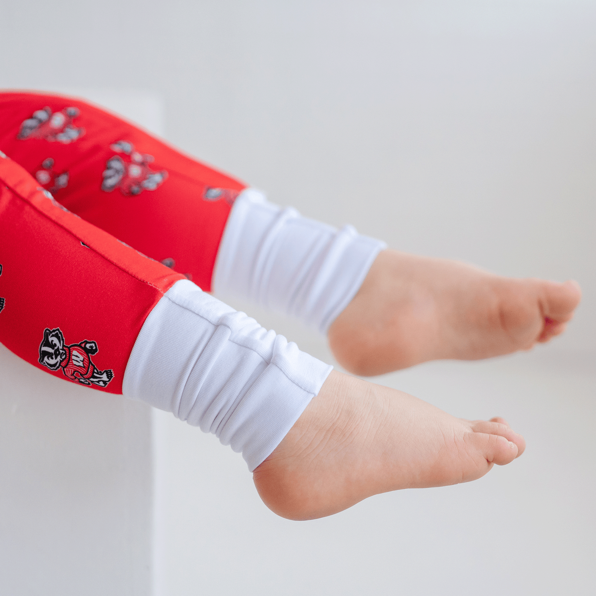 Wisconsin Badgers baby one-piece with official team logo, soft bamboo fabric, and double zippers for easy diaper changes.