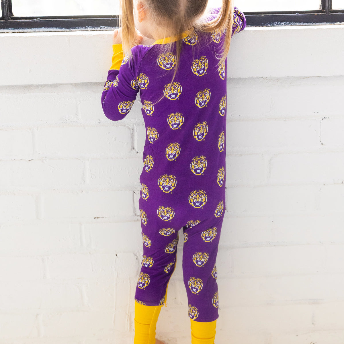 LSU Tigers Baby lounging in One-Piece sleeper on game day made from bamboo.
