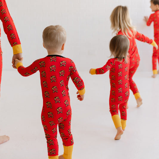 Children wearing matching red pajamas with a Maryland terrapins Testudo pattern.