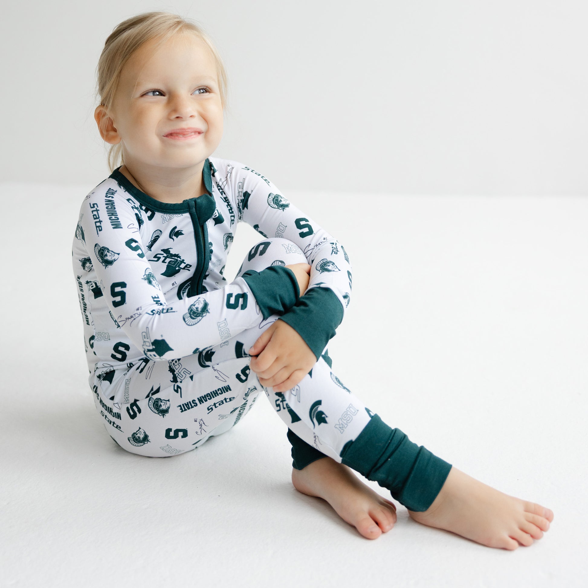 Official Michigan State Spartans baby game day sleeper with bamboo fabric and all-over logo design.