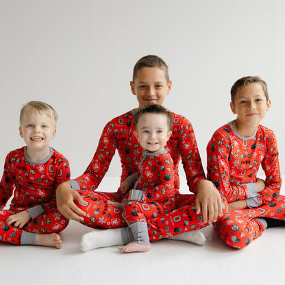 Four children wearing ohio state buckeyes bamboo red pajamas with a pattern on a white background