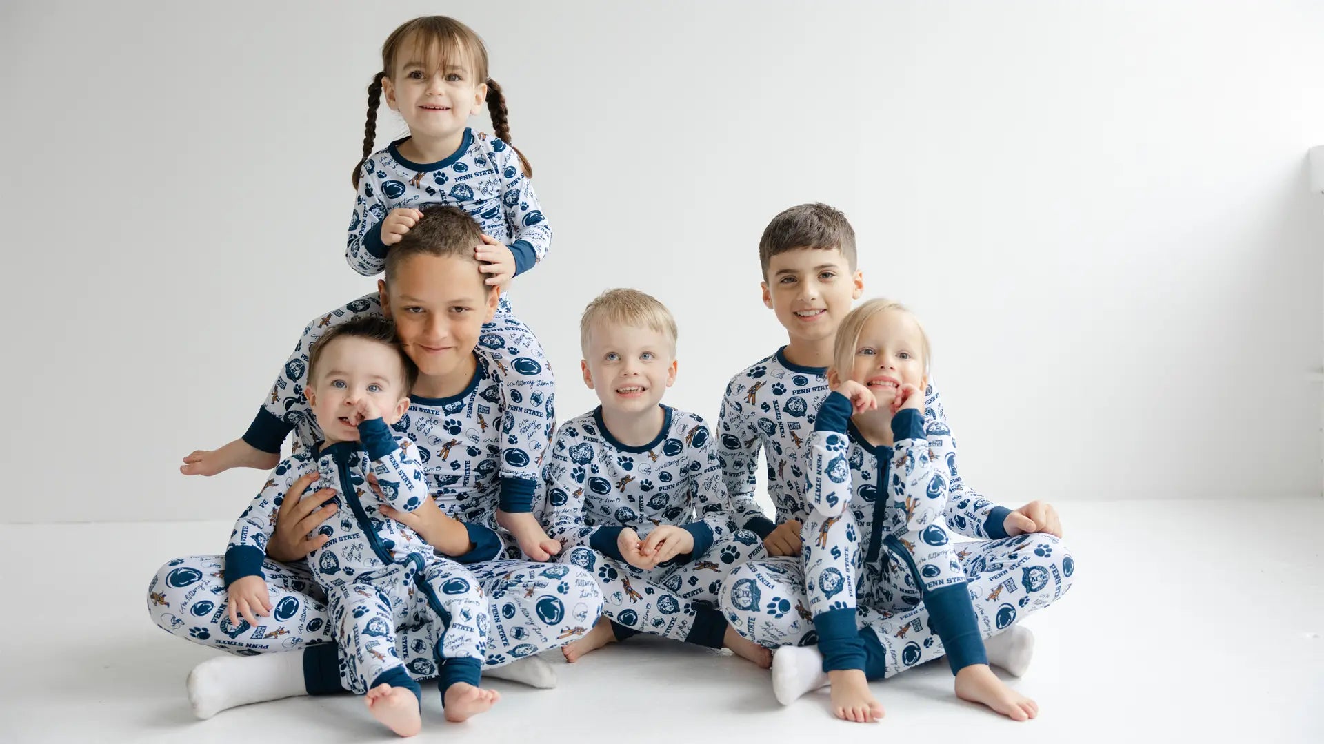 Children wearing matching Penn State Nittany Lions bamboo pajamas on a white background