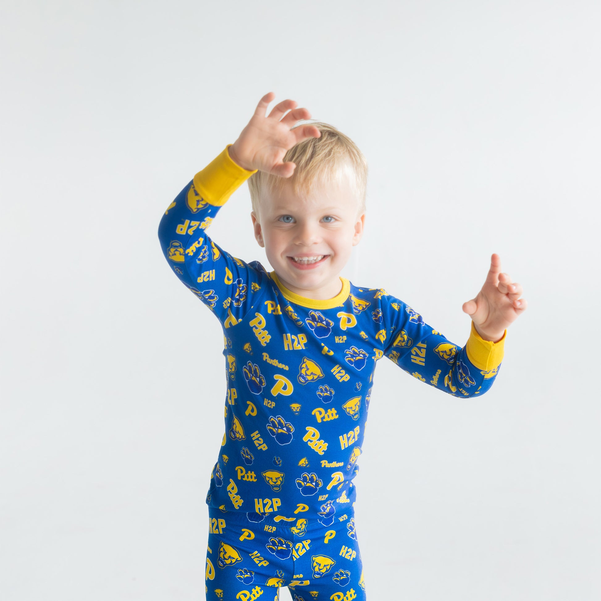 Child wearing blue pitt panthers pajamas with yellow accents on a white background