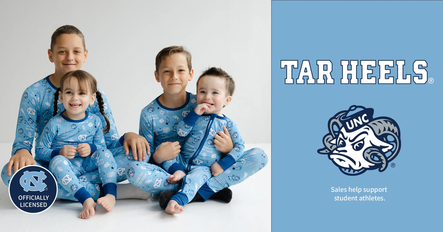 Four children in blue pajamas with a UNC logo on a white background