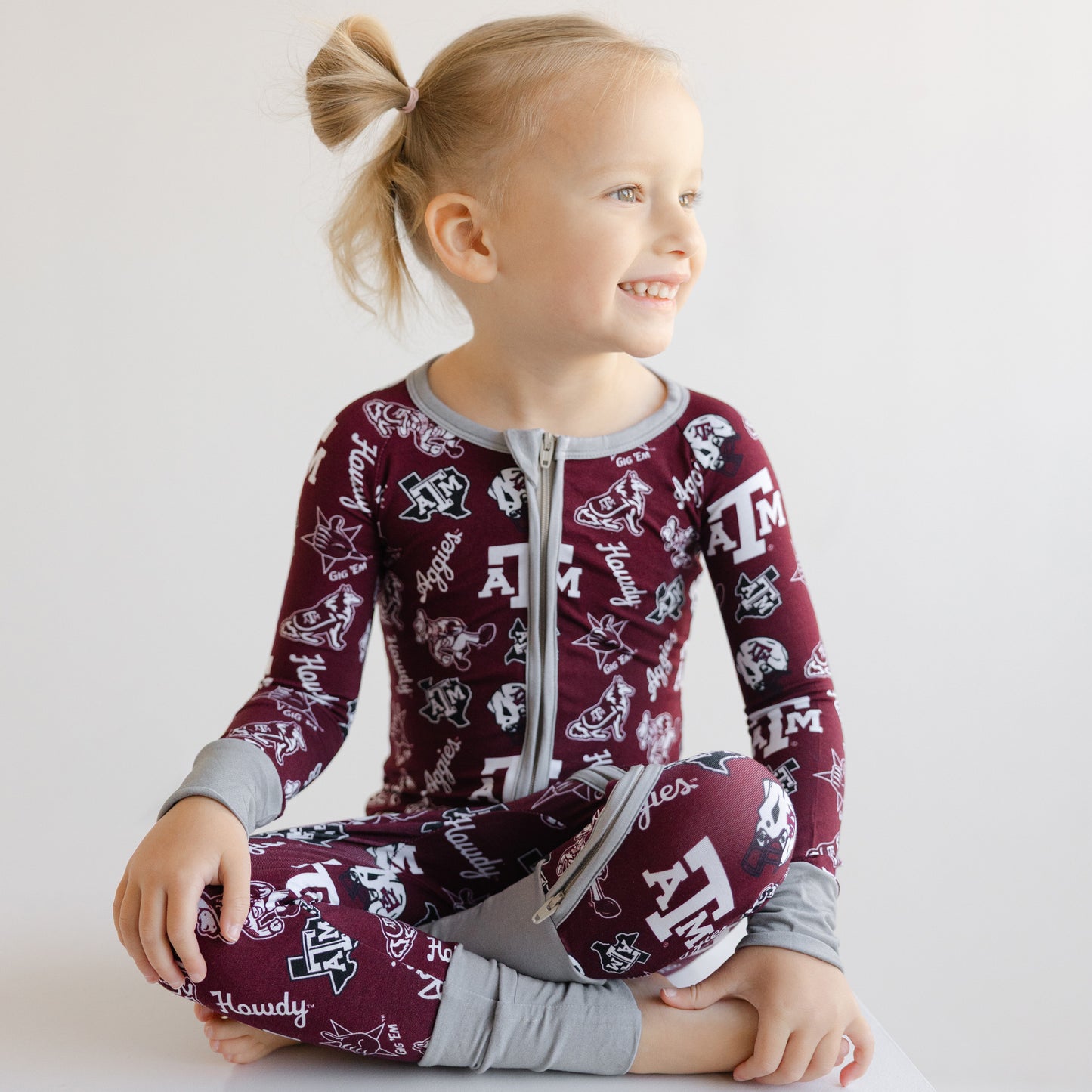Front view of a toddler girl's Texas A&M Aggies sleeper showing the two-way zipper