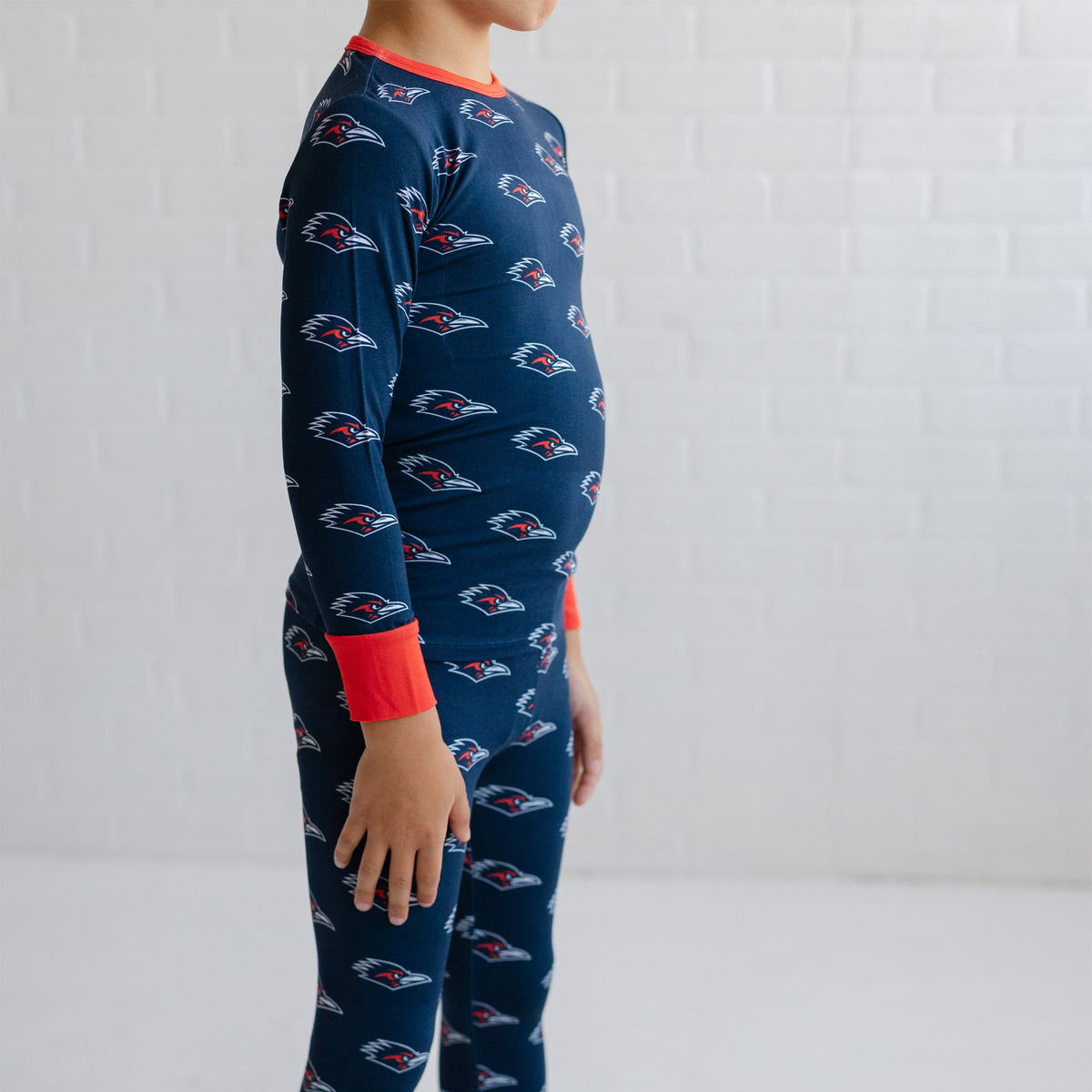 A child wearing a navy utsa roadrunners bamboo two piece pajama set. 