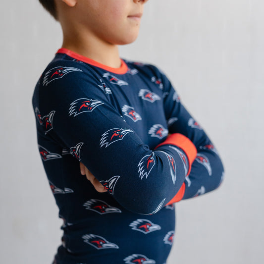 A child wearing a navy long-sleeve utsa roadrunners bamboo two piece pajama set. 