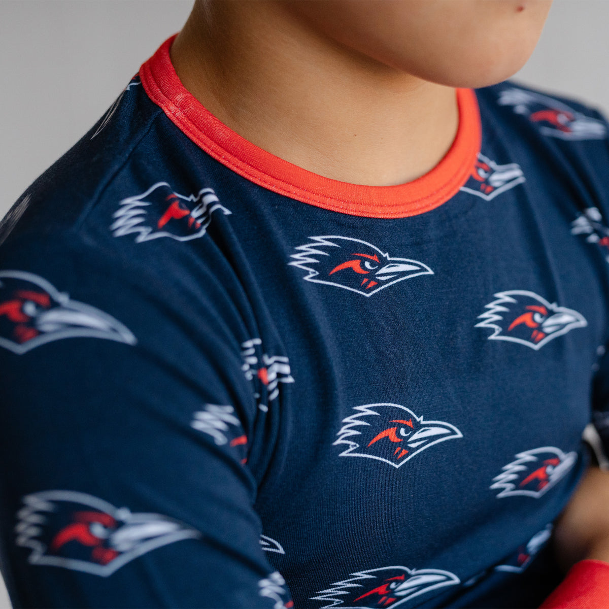 Close-up of a child wearing a navy utsa roadrunners bamboo two piece pajama set. 