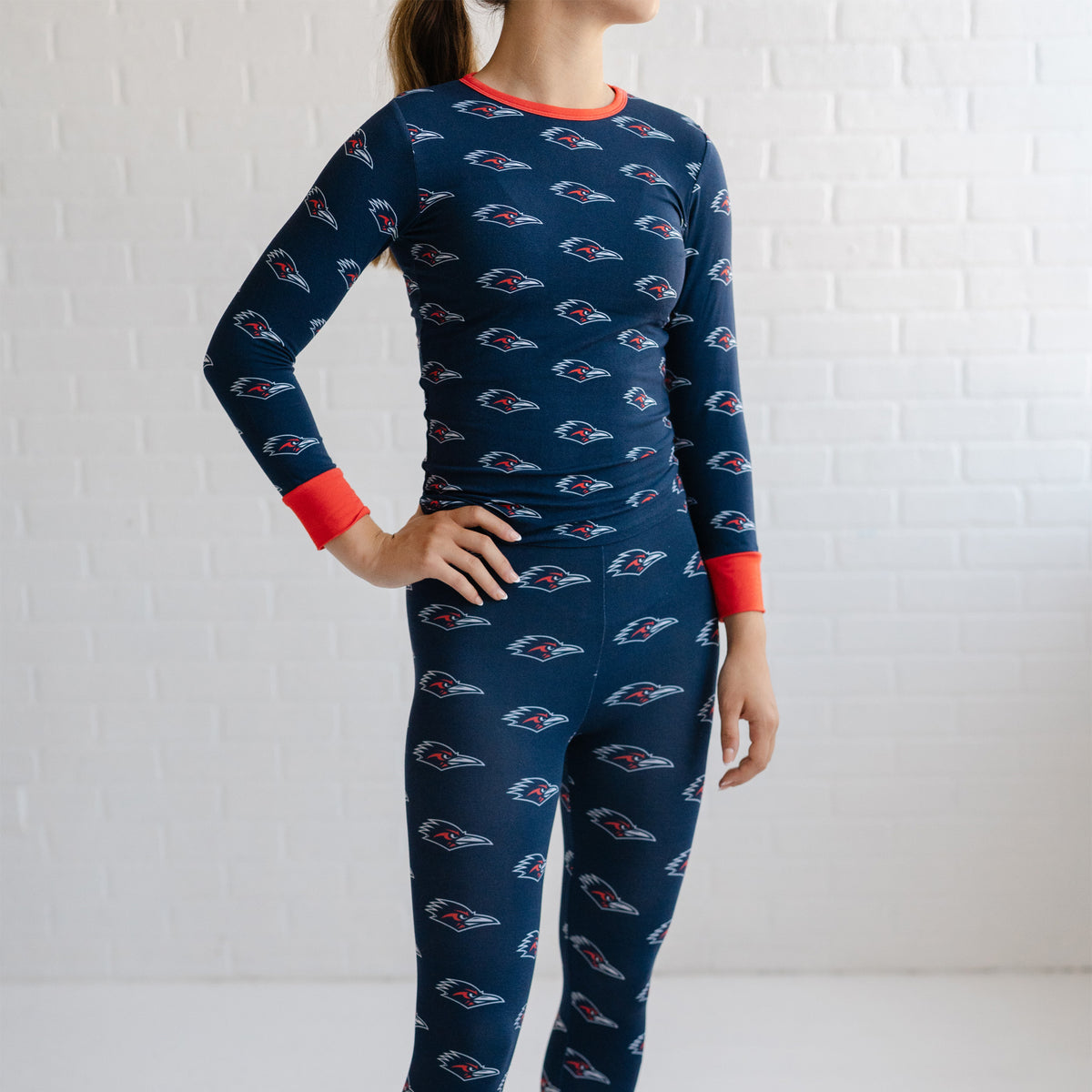 A girl youth wearing a navy utsa roadrunners bamboo two piece pajama set. 