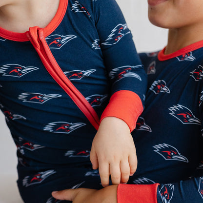 Close-up of a child wearing a navy UTSA roadrunners bamboo zipper one piece sleeper.