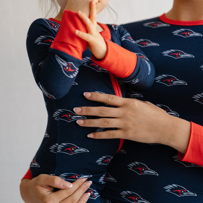 A close-up of a person and a child wearing matching UTSA roadrunners bamboo pajamas.